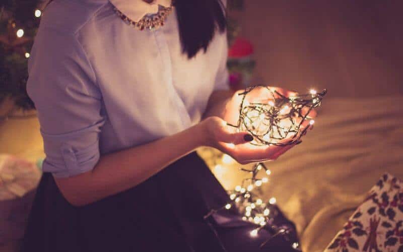 Woman holding Christmas lights in her hands