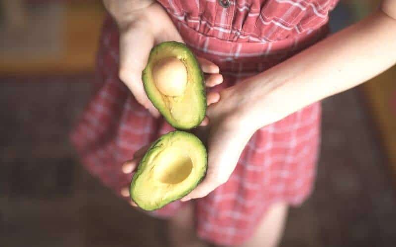 woman holding an avocado