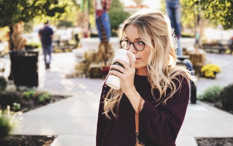 Woman outside drinking coffee