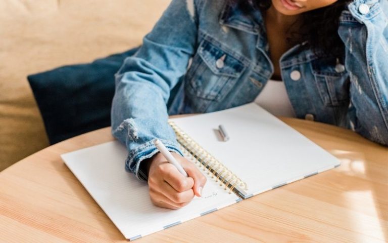 woman writing in gratitude journal