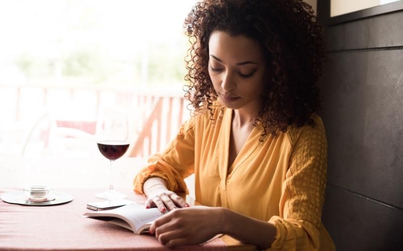 woman reading with a glass of wine