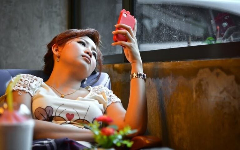 woman on phone at night looking bored