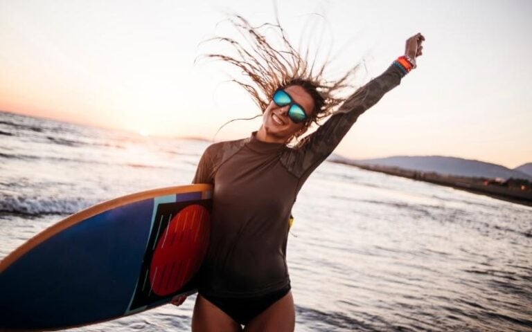 woman on beach with surf board