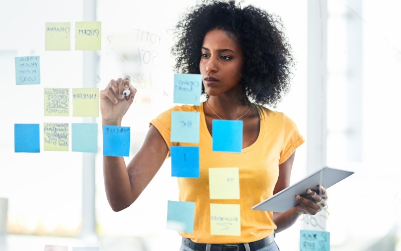 woman writing on sticky notes